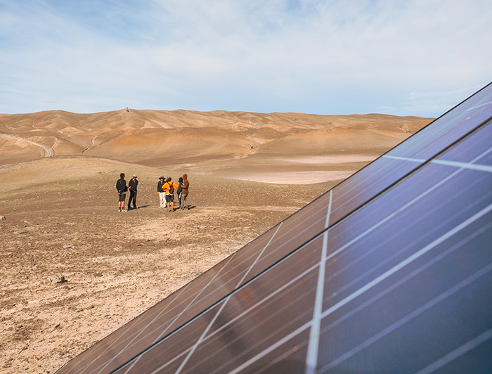 Panel solar y un grupo de estudiantes en el desierto