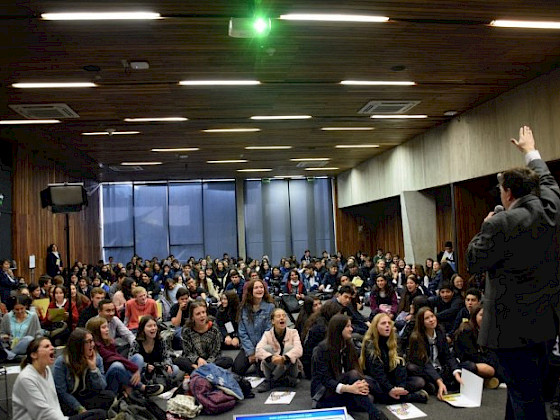 Jóvenes cantan entusiasmados frente a un sacerdote en el Encuentro Somos Iglesia.