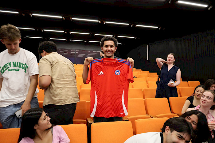 An exchange student holding a jersey from ”La Roja”