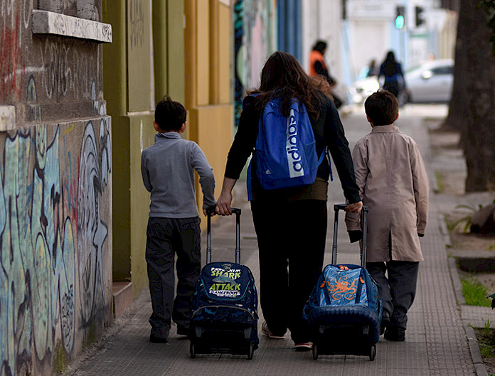 Mujer y dos niños caminando por la vereda
