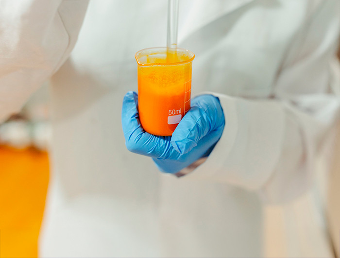 Experimento con un tubo de ensayo y un líquido naranja
