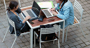 Jóvenes trabajando con notebooks en el patio