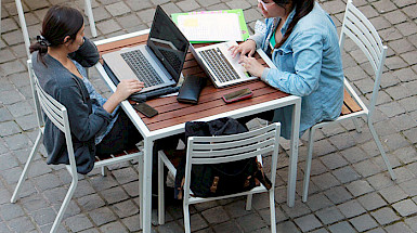 Jóvenes trabajando con notebooks en el patio
