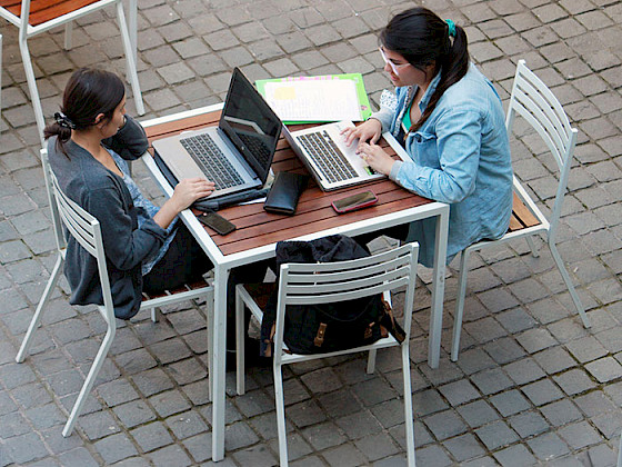 Jóvenes trabajando con notebooks en el patio