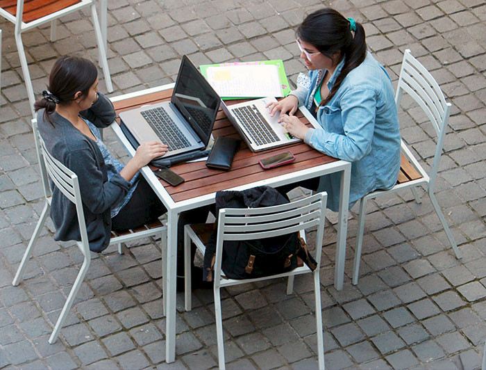 Jóvenes trabajando con notebooks en el patio