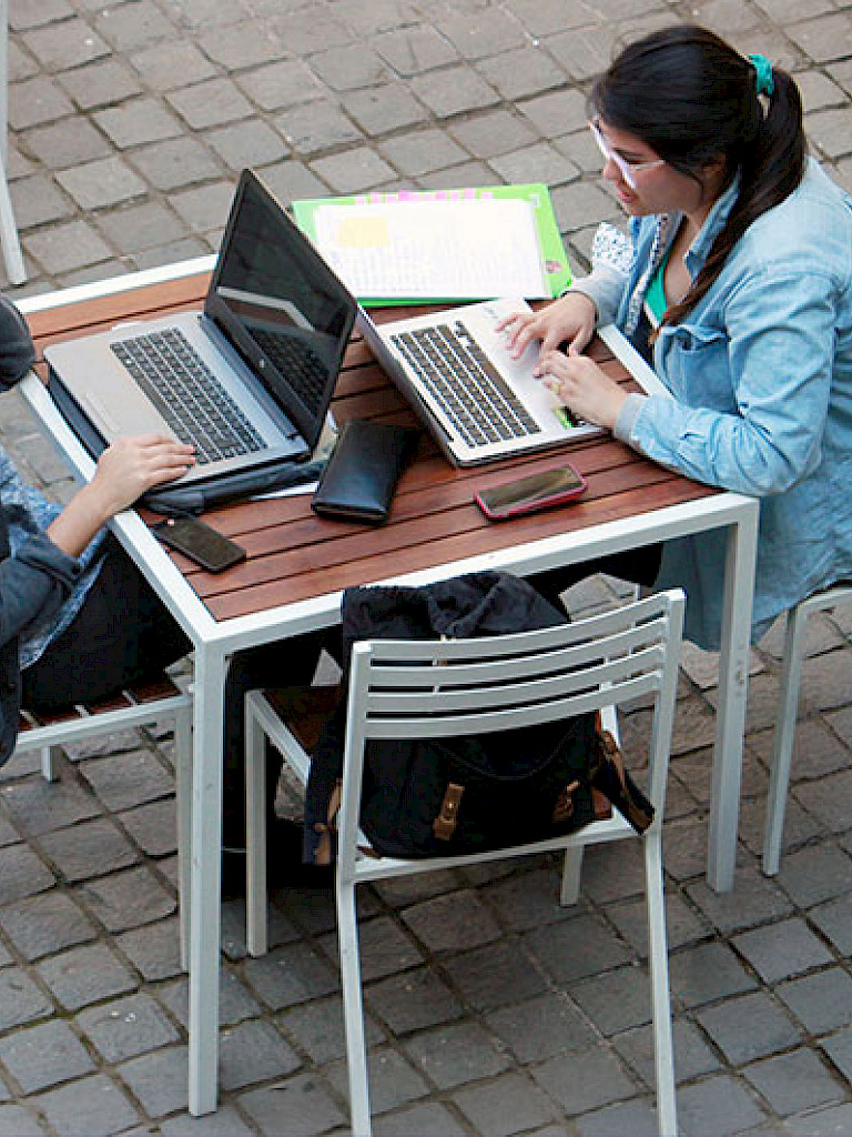 Jóvenes trabajando con notebooks en el patio