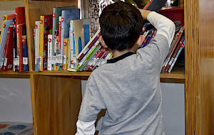 Niño sacando un libro de un estante