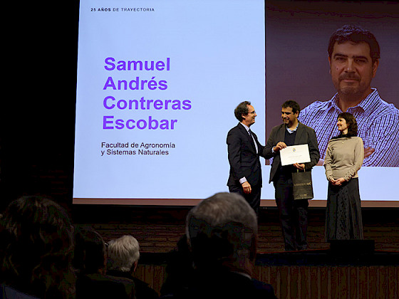 Rector entregando el reconocimiento a un académico