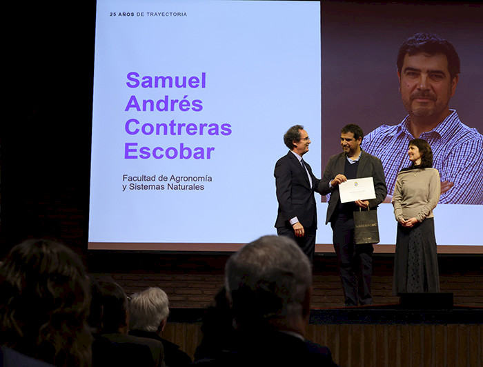Rector entregando el reconocimiento a un académico