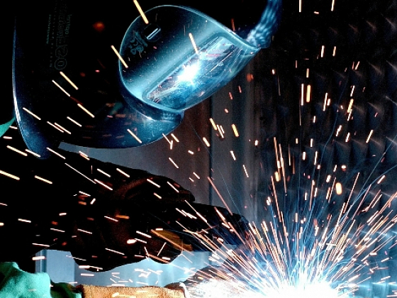 Soldador trabajando, con casco puesto y protegiendo su vista