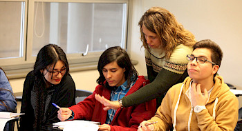 Estudiantes conversando en una sala de clases.