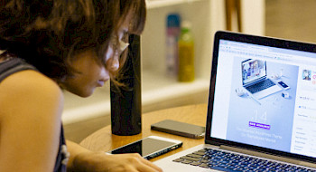 Mujer estudiantdo frente a la pantalla de un computador.