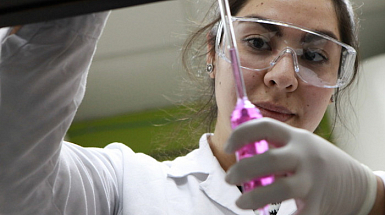 Una estudiante sosteniendo un instrumento en un laboratorio.