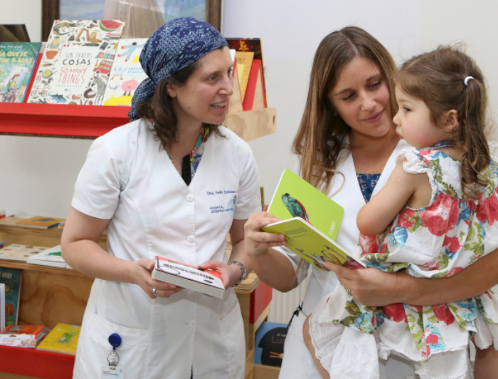 Mujer cuenta cuentos a niños que participan de la Biblioteca Escolar Futuro en el Hospital Josefina Martínez