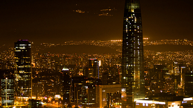 Fotografía de Santiago de Chile nocturno. Ciudad iluminada y Costanera Center de fondo.