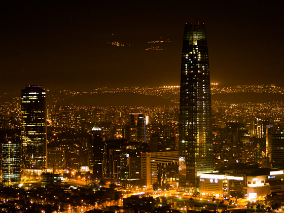 Fotografía de Santiago de Chile nocturno. Ciudad iluminada y Costanera Center de fondo.