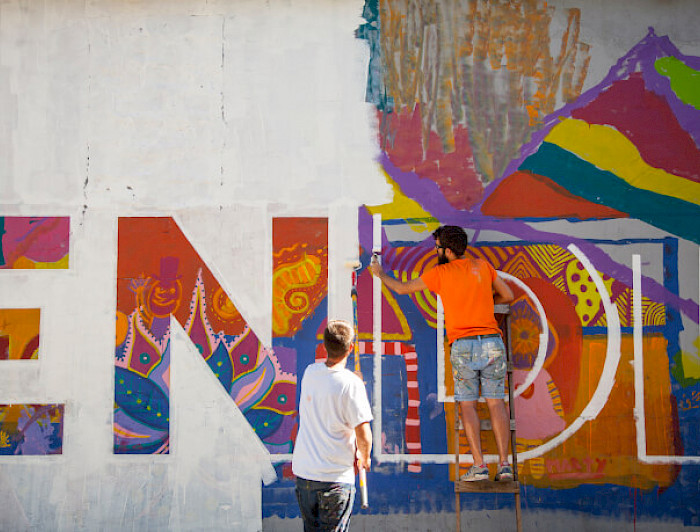 Dos hombres pintan el mural Simbiosis ubicado en la comuna de Recoleta