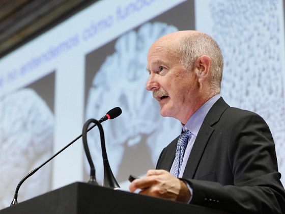 Científico españo Rafael Yuste hablando en un podio.