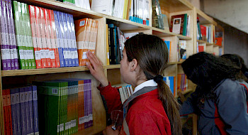 Una escolar tomando un libro, en una de las sedes de Biblioteca Escolar Futuro.
