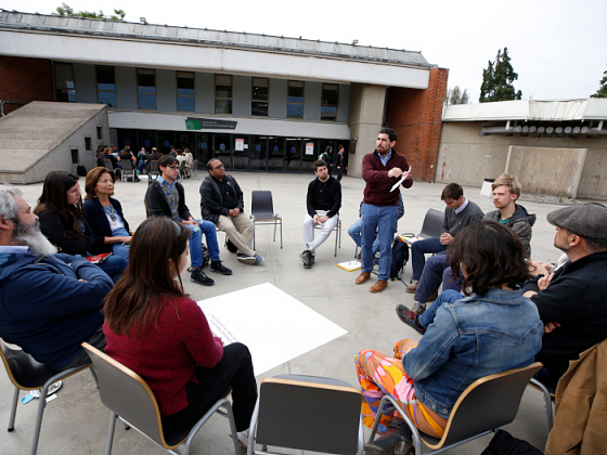 Grupo de gente sentada en circulo.