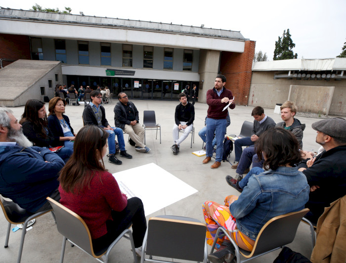 Grupo de gente sentada en circulo.