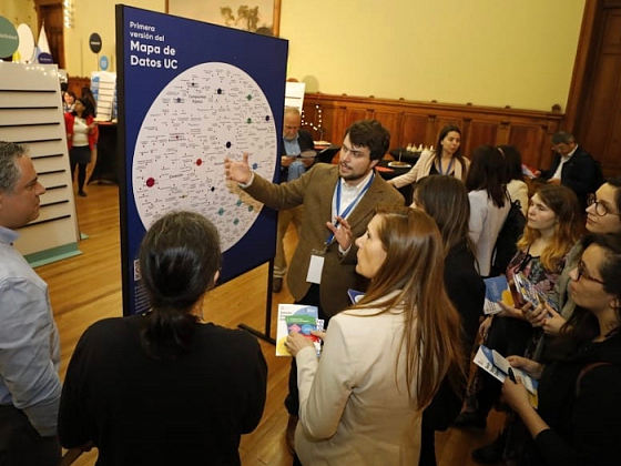 Personas mirando un mapa de datos en un atril.