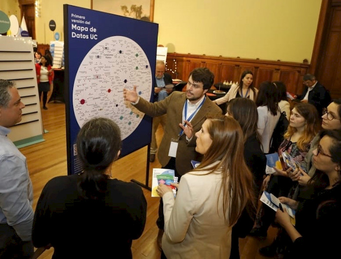 Personas mirando un mapa de datos en un atril.