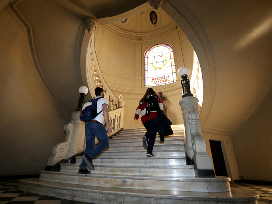 Alumnos subiendo por la escalera del hall de Casa Central UC