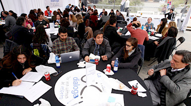 Grupo de personas conversando en una mesa del UC Dialoga 2019