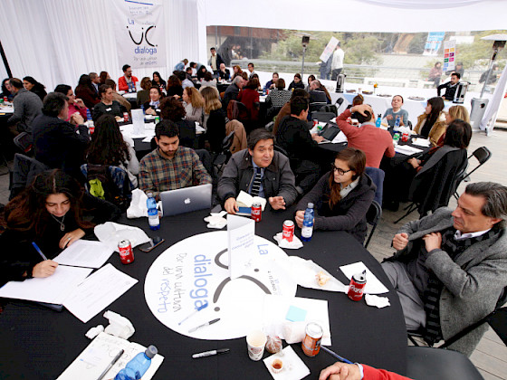 Grupo de personas conversando en una mesa del UC Dialoga 2019