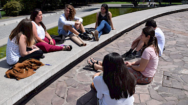 Grupo de mujeres sentadas en el suelo conversando.