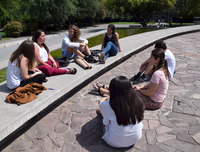 Grupo de mujeres sentadas en el suelo conversando.