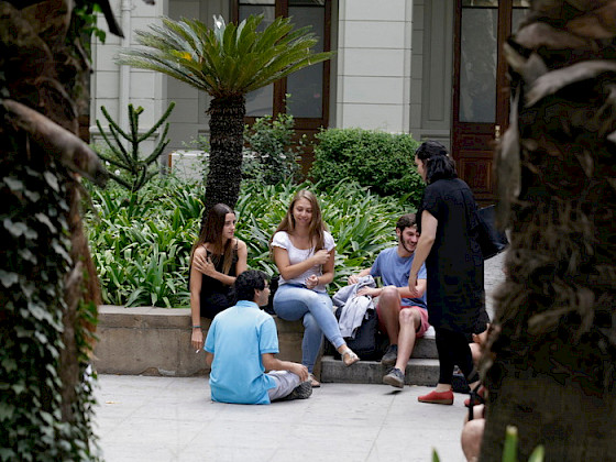 Grupo de jóvenes conversando en un patio de Casa Central.