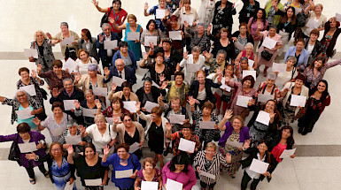 Grupo de adultos mayores mostrando sus diplomas.