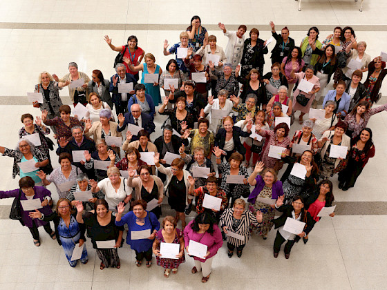Grupo de adultos mayores mostrando sus diplomas.