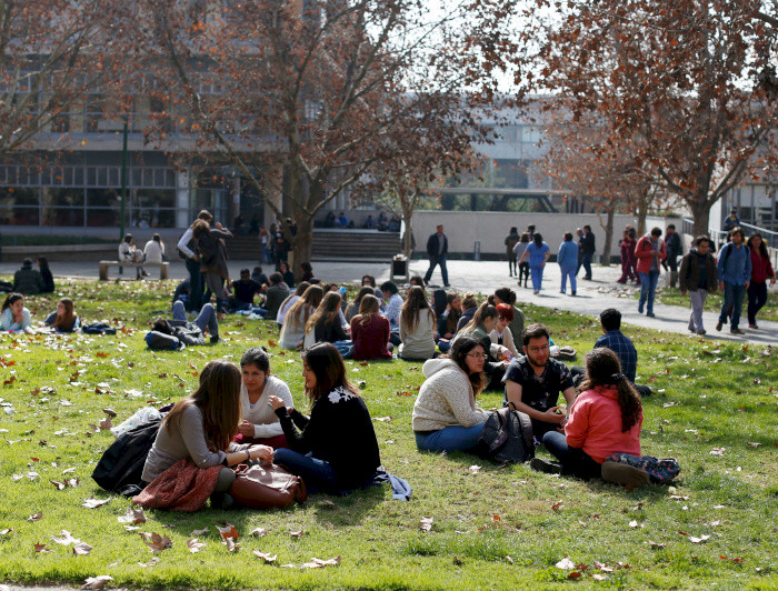 Jóvenes conversando en el pasto del campus  San Joaquín.