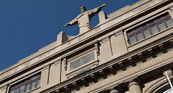 Fachada del campus Casa Central, con el Cristo de manera diagonal. Fotografía: Banco de Imágenes UC.
