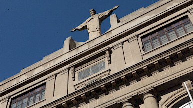 Fachada del campus Casa Central, con el Cristo de manera diagonal. Fotografía: Banco de Imágenes UC.