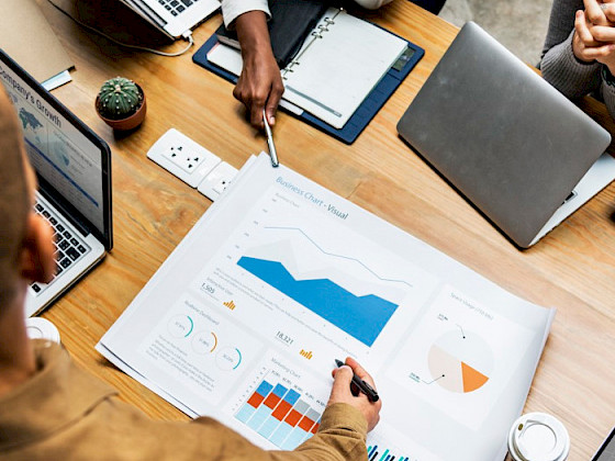 Personas sentadas en una sala de reuniones, frente a un gráfico.