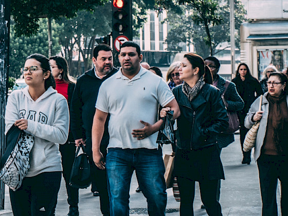 Gente caminando por la calle, mirando para distintos lados.