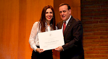 La profesora María Elena Santibáñez recibiend su diploma de parte del rector Ignacio Sánchez.