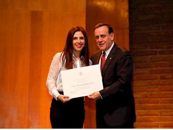 La profesora María Elena Santibáñez recibiend su diploma de parte del rector Ignacio Sánchez.