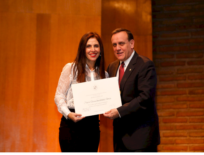 La profesora María Elena Santibáñez recibiend su diploma de parte del rector Ignacio Sánchez.