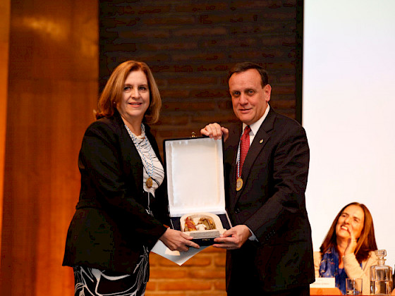 La profesora Silvia Pellegrini recibe el premio Monseñor Carlos Casanueva de parte del rector Ignacio Sánchez.