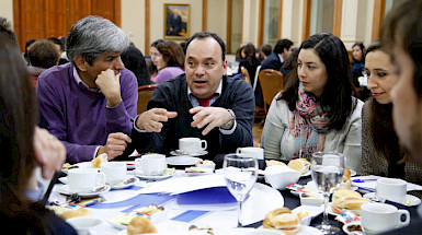 Profesionales de la Universidad sentados conversando en La UC Dialoga.