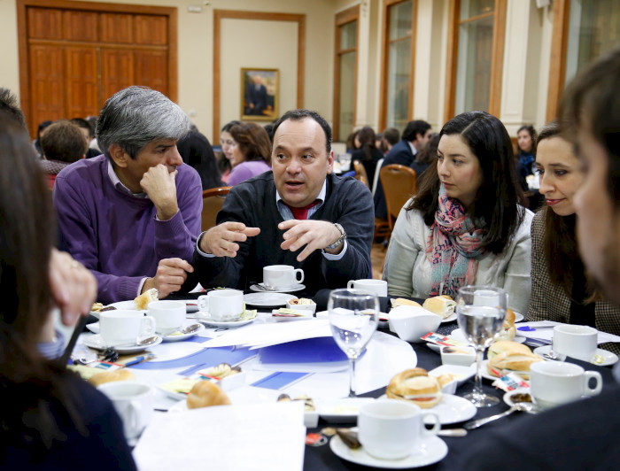 Profesionales de la Universidad sentados conversando en La UC Dialoga.