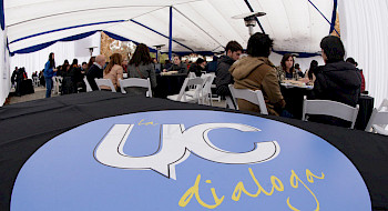 Logo de La UC Dialoga, con personas sentadas en unas mesas al fondo.