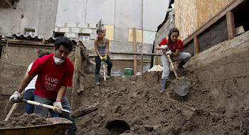 Tres voluntarios excavando la tierra con una pala.
