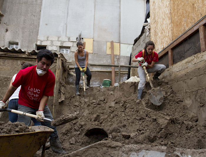 Tres voluntarios excavando la tierra con una pala.