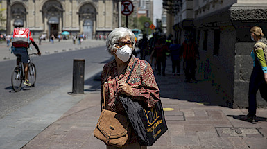 Persona mayor con mascarilla detenida en la calle y de fondo se ve la Catedral Metropolitana